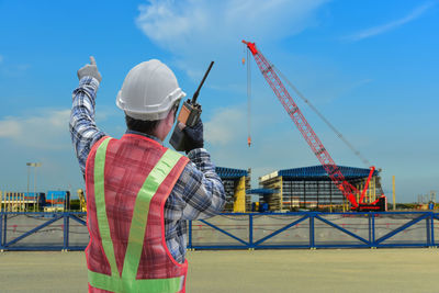 Man working at construction site against sky