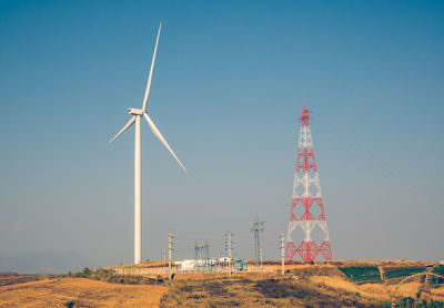 Windmill on field against clear sky