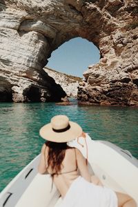 Midsection of woman on rock by sea