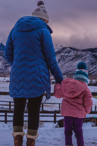 Rear view of couple walking on snow