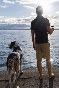 Full length of dog standing on beach against sky