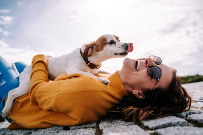 Woman lying down on floor with dog outdoors