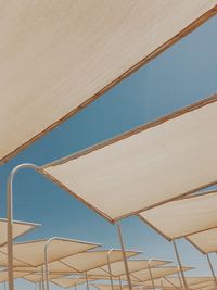 Low angle view of parasol against blue sky