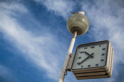 Low angle view of clock against sky