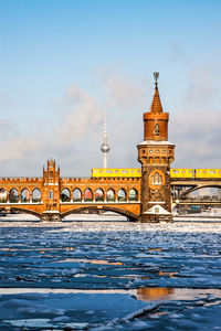 Bridge over river in city during winter