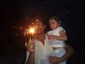 Full length of girl holding sparkler at night