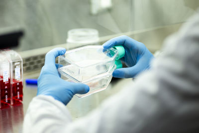 Midsection of scientist examining chemical in laboratory