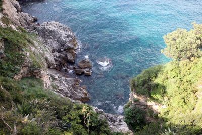 High angle view of rocks on sea shore