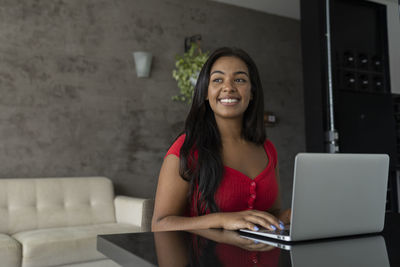 Young black woman working at home with laptop on desk. home office concept. gray notebook. 