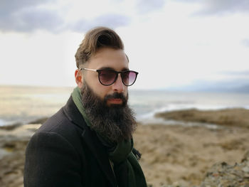 Portrait of bearded man in sunglasses at beach
