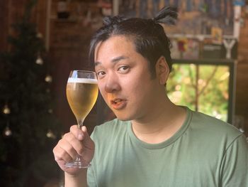 Portrait of young man drinking glass