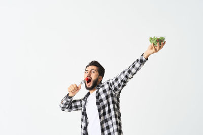 Man holding umbrella against white background