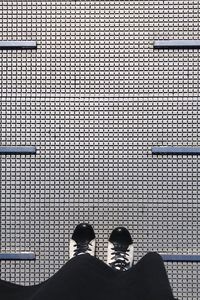 Low section of man standing on metal grate