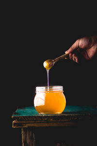 Close-up of hand pouring drink in glass