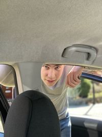 Portrait of man looking through car