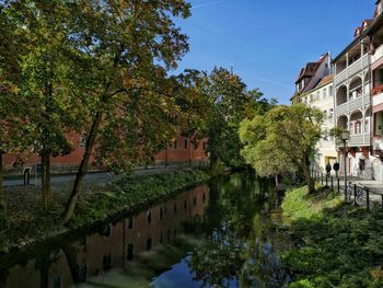 Canal amidst buildings in town against sky