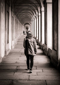 Rear view of man walking on walkway