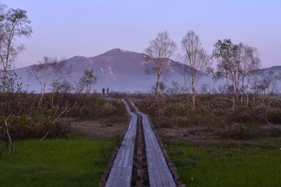 Narrow pathway along countryside landscape