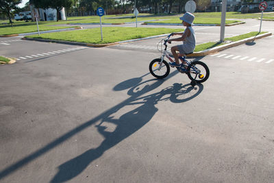 Boy riding bicycle on road