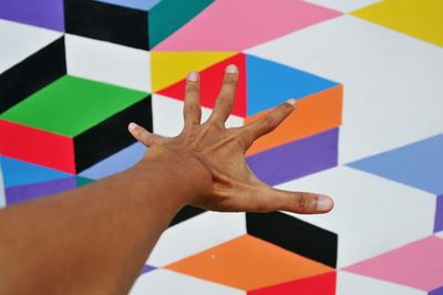 High angle view of human hand against colored wall