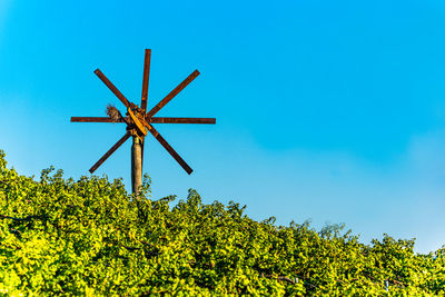 Low angle view of wind turbine against blue sky