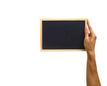 Close-up of hand holding paper over white background