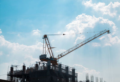 Working crane on the rooftop building with blue sky and cloud. construction grow up everyday.