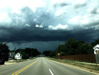 Empty road against cloudy sky