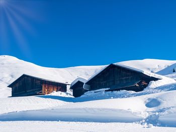 Houses against snowcapped mountains against clear blue sky