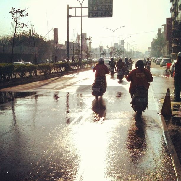 water, reflection, building exterior, street, wet, lifestyles, walking, city, rain, full length, men, puddle, architecture, leisure activity, city life, built structure, person, season