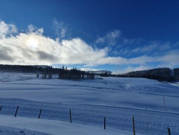Scenic view of snow covered field against sky