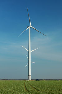 Windmill on field against sky