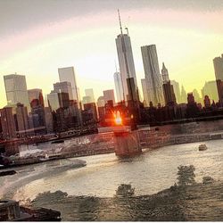 Skyscrapers in city at sunset