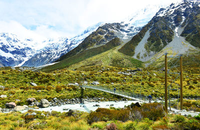 Footbridge by snowcapped mountains at mt cook national park