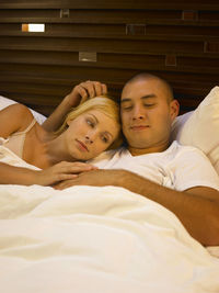 High angle view of couple relaxing on bed at home