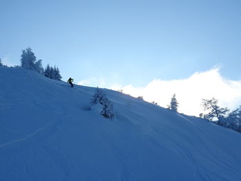 Person skiing on snowcapped mountain against sky