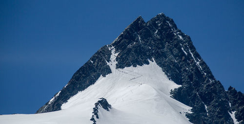 Scenic view of snowcapped mountains against clear blue sky