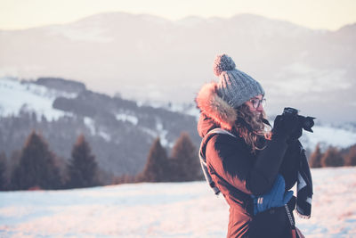 Man wearing hat standing on snow covered mountain