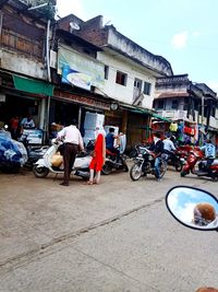 People on street against buildings in city