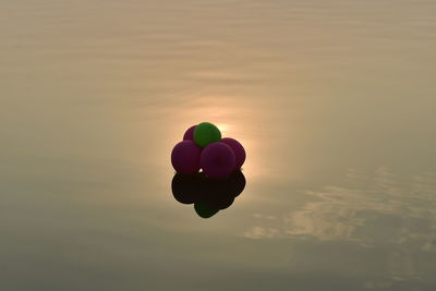 Close-up of heart shaped balloons against sky during sunset