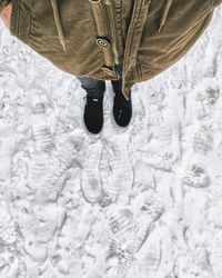Low section of man standing on snow