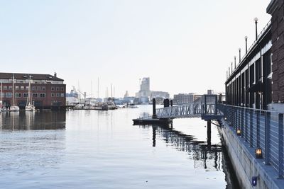 Buildings by river against sky in city