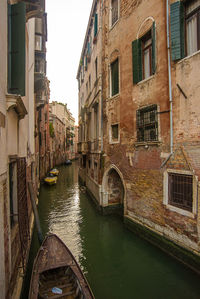 Canal amidst buildings against sky