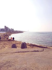 People at beach against clear sky