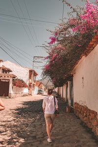 Full-length rear view of woman walking on the footpath of a colombian colony town villa de leyva.