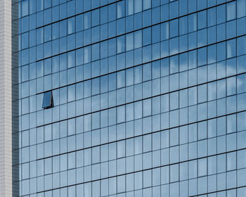 Low angle view of glass building against clear sky