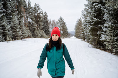 Portrait of woman skiing on snow covered field