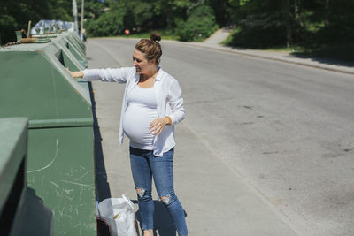 Full length of woman standing on road in city