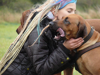 Midsection of woman kissing a dog