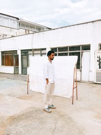 Full length of man standing against white wall